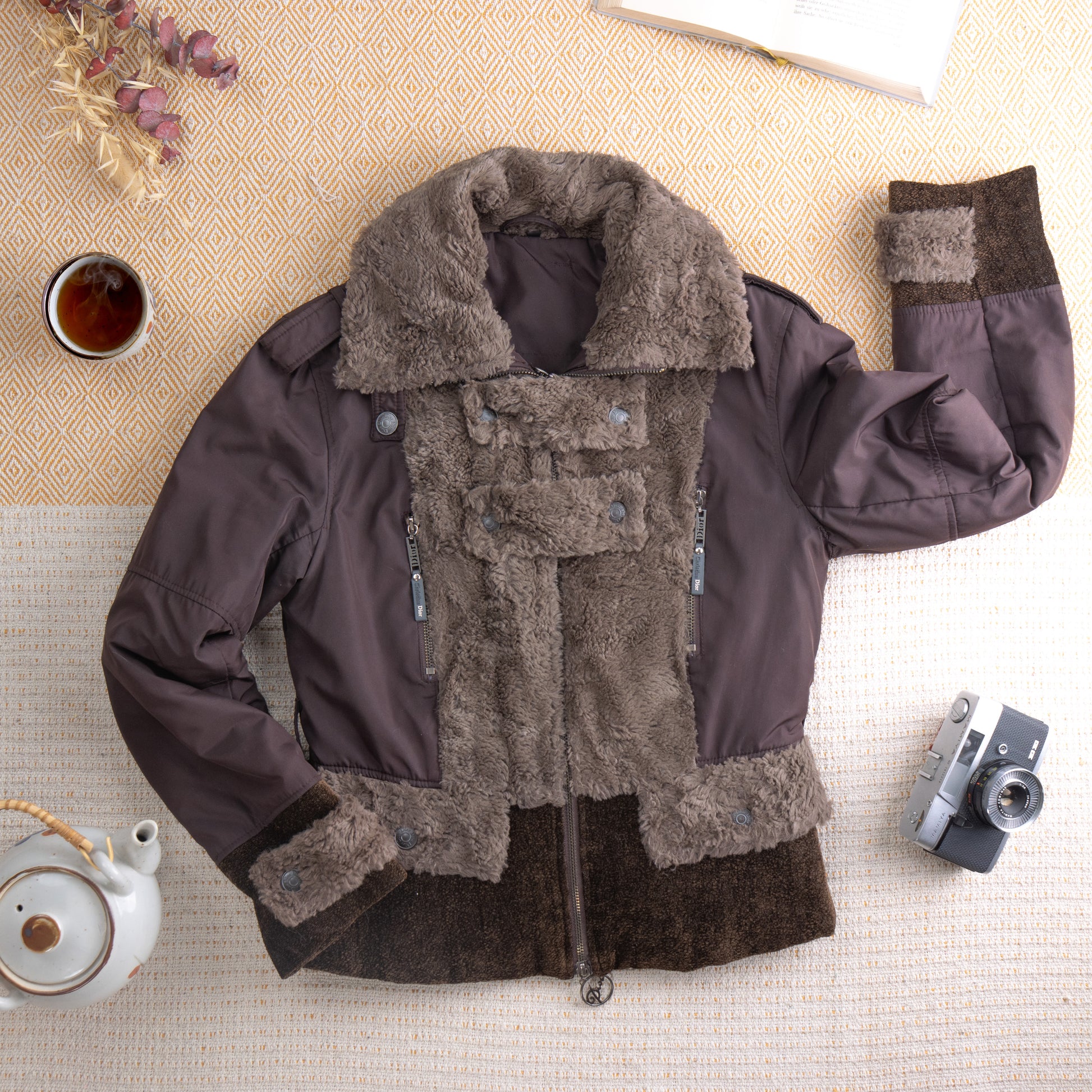 Rare Christian Dior by John Galliano 2002 Y2K Snow Bunny Aviator Jacket – chocolate brown nylon shell with oversized taupe curly faux fur lapel collar and front panel, double zip closure with silver hardware, silver snap buttons, dark brown boucle hem and cuff trim, padded sleeves, Made in France, flat lay editorial shot