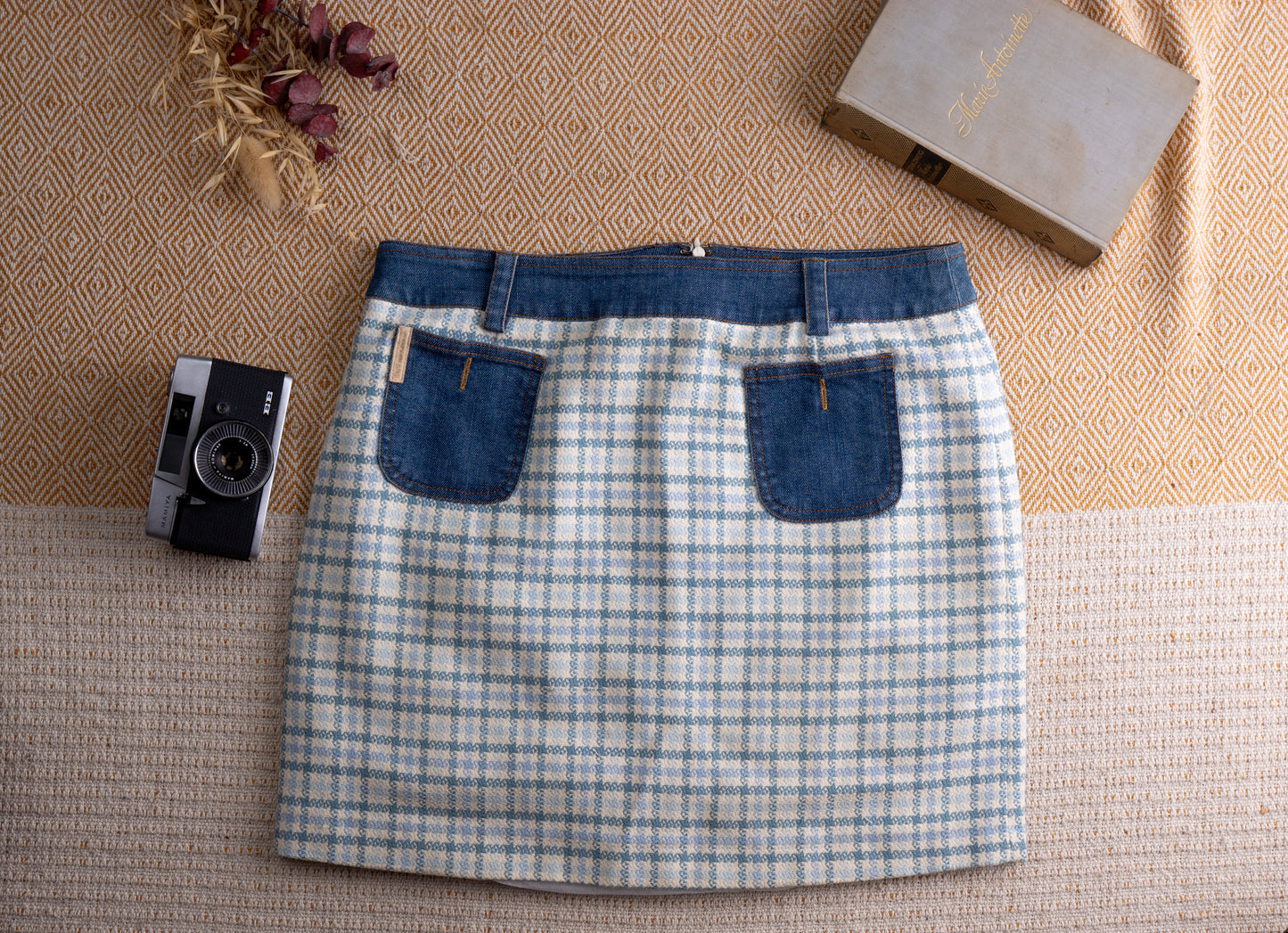Vintage D&G Dolce Gabbana Y2K Mixed Media Mini Skirt – pale blue and white houndstooth tweed body with contrasting indigo denim waistband, two denim patch pockets with gold D&G logo patch, back zip closure, straight mini silhouette, flat lay editorial shot
