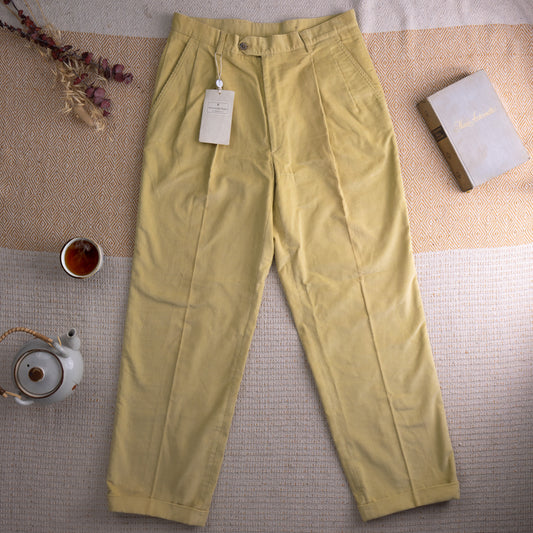 Vintage Ermenegildo Zegna Deadstock NWT Corduroy Trousers – soft butter yellow fine-wale corduroy, high waist with double forward pleats, single button closure, side pockets, turn-up cuffs, tapered straight leg, original Zegna hang tag attached, Made in Italy, flat lay editorial shot