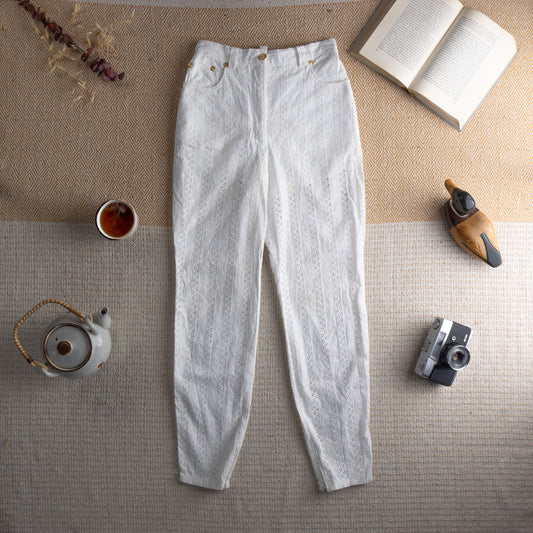 Vintage Versus Versace 90s White Eyelet Lace Trousers – white broderie anglaise cotton with vertical eyelet lace stripe panels, high waist with gold Versace lion-head buttons, two front pockets, tapered slim leg, Italian summer luxury, flat lay editorial shot