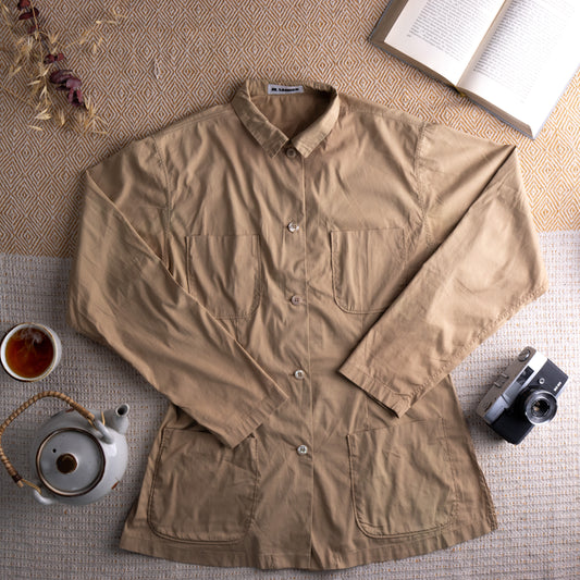 Vintage Jil Sander 90s Archival Safari Shirt – sun-faded khaki beige cotton, point collar, long sleeves with button cuffs, button-front, dual chest patch pockets, dual hip patch pockets, tailored minimalist utility silhouette, Jil Sander label at collar, flat lay editorial shot
