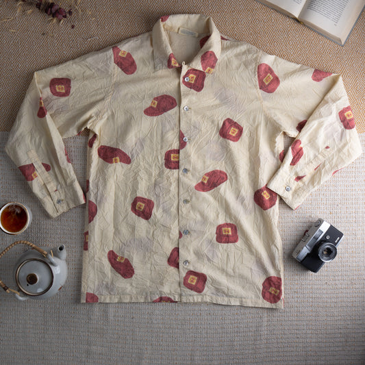 HAI Sporting Gear by Issey Miyake Archival 80s Crinkle Texture Shirt – cream off-white permanently crinkled fabric with all-over abstract red oval and square print motifs with small orange stamp detail, point collar, button-front, long sleeves with button cuffs, boxy relaxed fit, Japanese designer archive, flat lay editorial shot
