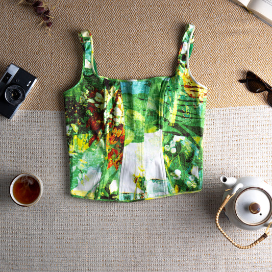 Archival Iceberg 90s Corset Bustier Top – abstract impressionist garden print in emerald green, white, yellow and red on structured cotton, square neckline, wide shoulder straps, boned seam panelling, hook-and-eye back closure, cropped silhouette, mint condition fairycore grunge designer piece, flat lay editorial shot