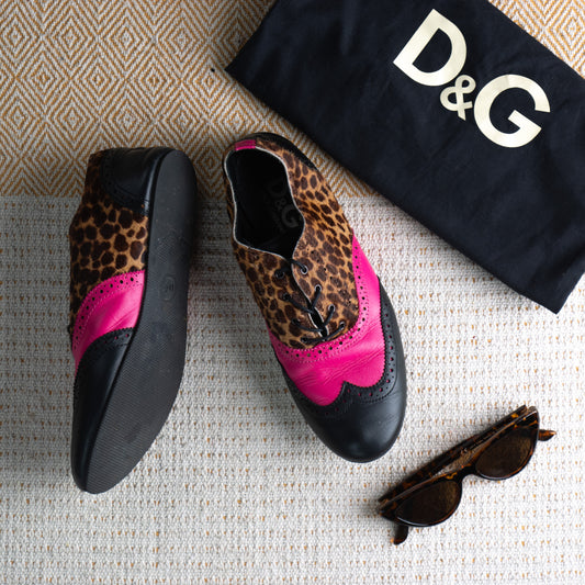 D&G Dolce Gabbana Y2K Leopard Pony Hair Oxford Brogues – mixed media lace-up flats with tan leopard print calf hair upper, hot pink leather wingtip saddle panel, black leather toe cap and heel, brogue perforations, black lace-up closure, D&G dust bag included, mob wife Italian designer, flat lay editorial shot
