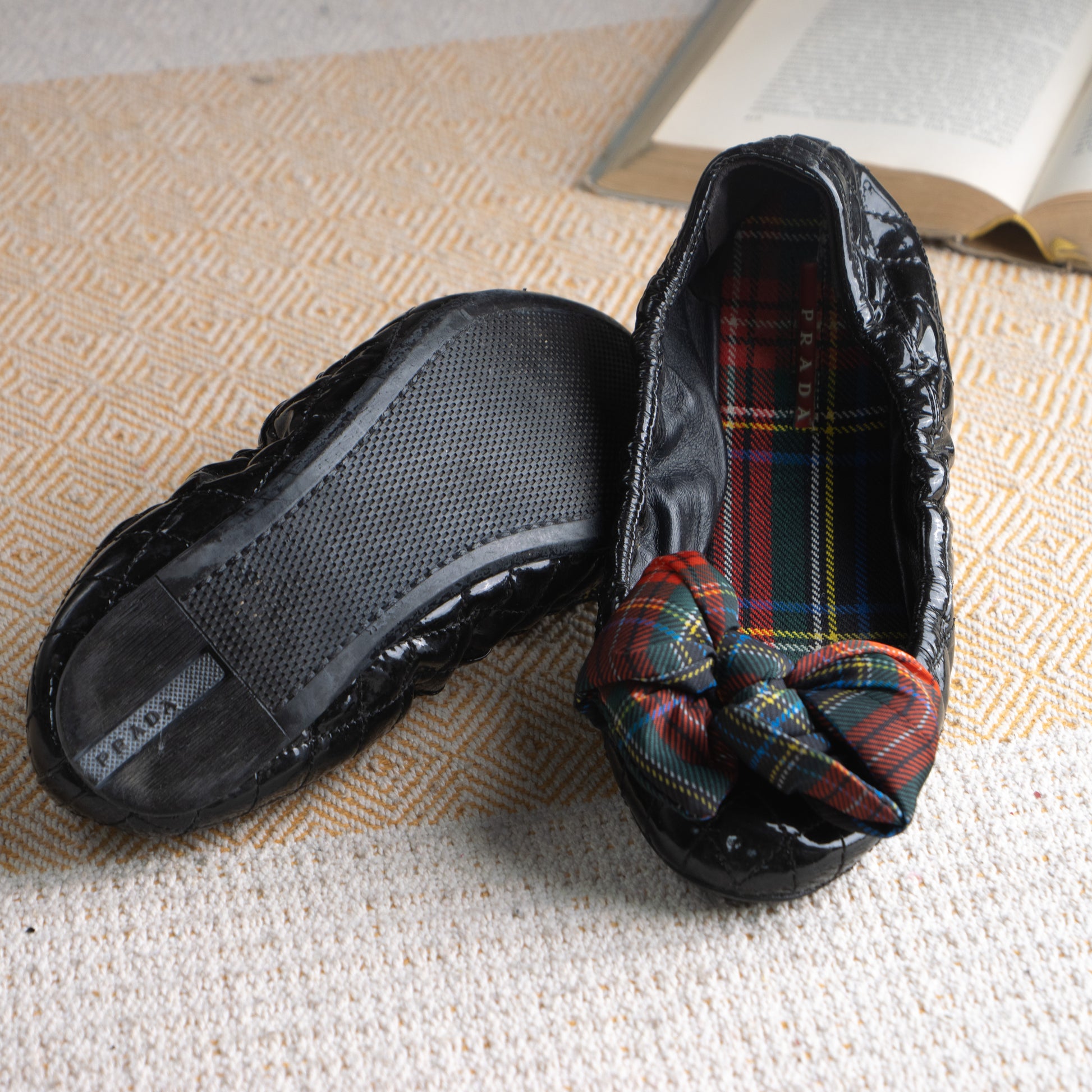 Prada Gaufré 2006 Launch Collection Ballet Flats – black quilted patent leather with signature gaufré texture, round toe, multicolour red and green tartan plaid bow detail at toe, matching tartan fabric lining, Prada logo insole, rubber sole, dark academia archival collector piece, flat lay product shot