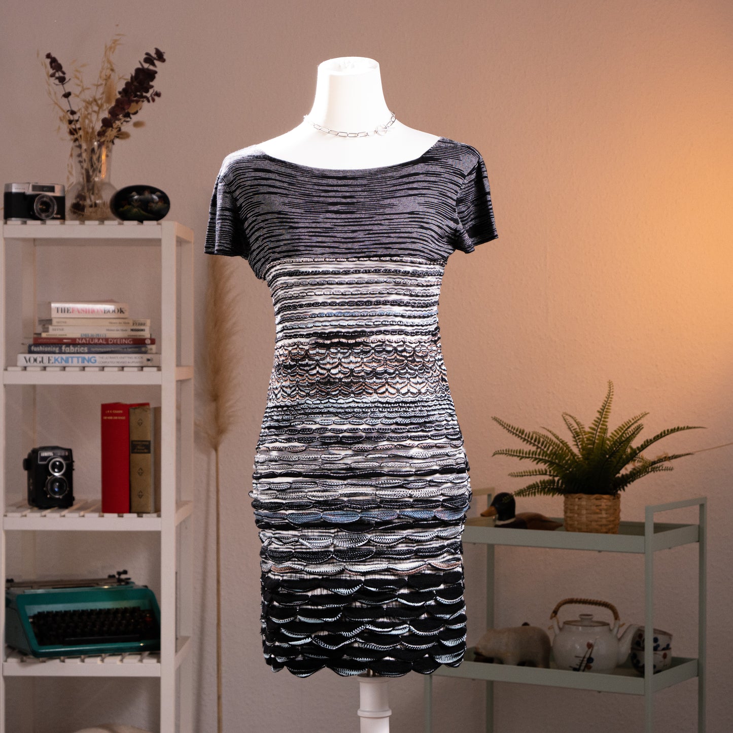 Archival Missoni Orange Label 90s 3D Scalloped Knit Mini Dress – black and silver metallic knit, wide scoop neckline, short sleeves, horizontal stripe bodice transitioning into dramatic 3D raised scallop shell texture panels at waist and skirt, body-con silhouette, textile sculpture Angela Missoni era, product shot on dress form