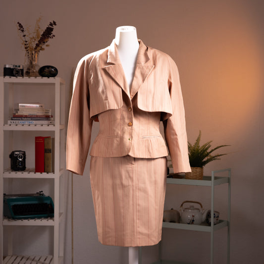 Archival Chantal Thomass 90s 3-Piece Pinstripe Wool Suit – blush pink wool with tonal pinstripe, cropped blazer with wide notch lapel and dramatic cape-back panel, gold button-front, matching boned corset vest, pencil midi skirt, couture craftsmanship, product shot on dress form