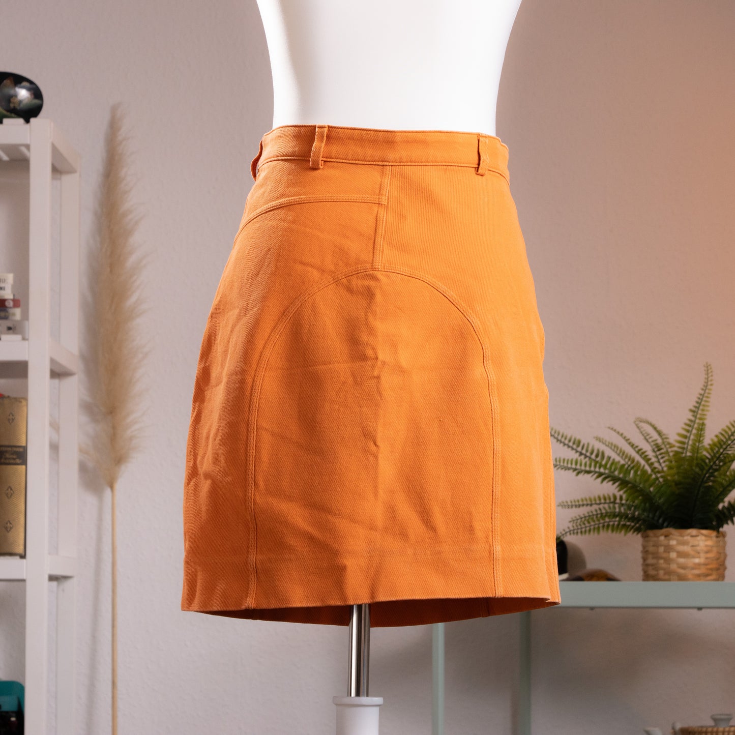 back view Archival Gucci by Tom Ford 1999 Orange Ottoman Utility Mini Skirt  sample prototype atelier– saturated carrot orange structured ottoman fabric, low rise with single gold button and belt loops, asymmetric curved seam panelling at front, dual zip pocket detail at waistband, clean A-line mini silhouette, atelier sample IT 42, product shot on dress form
