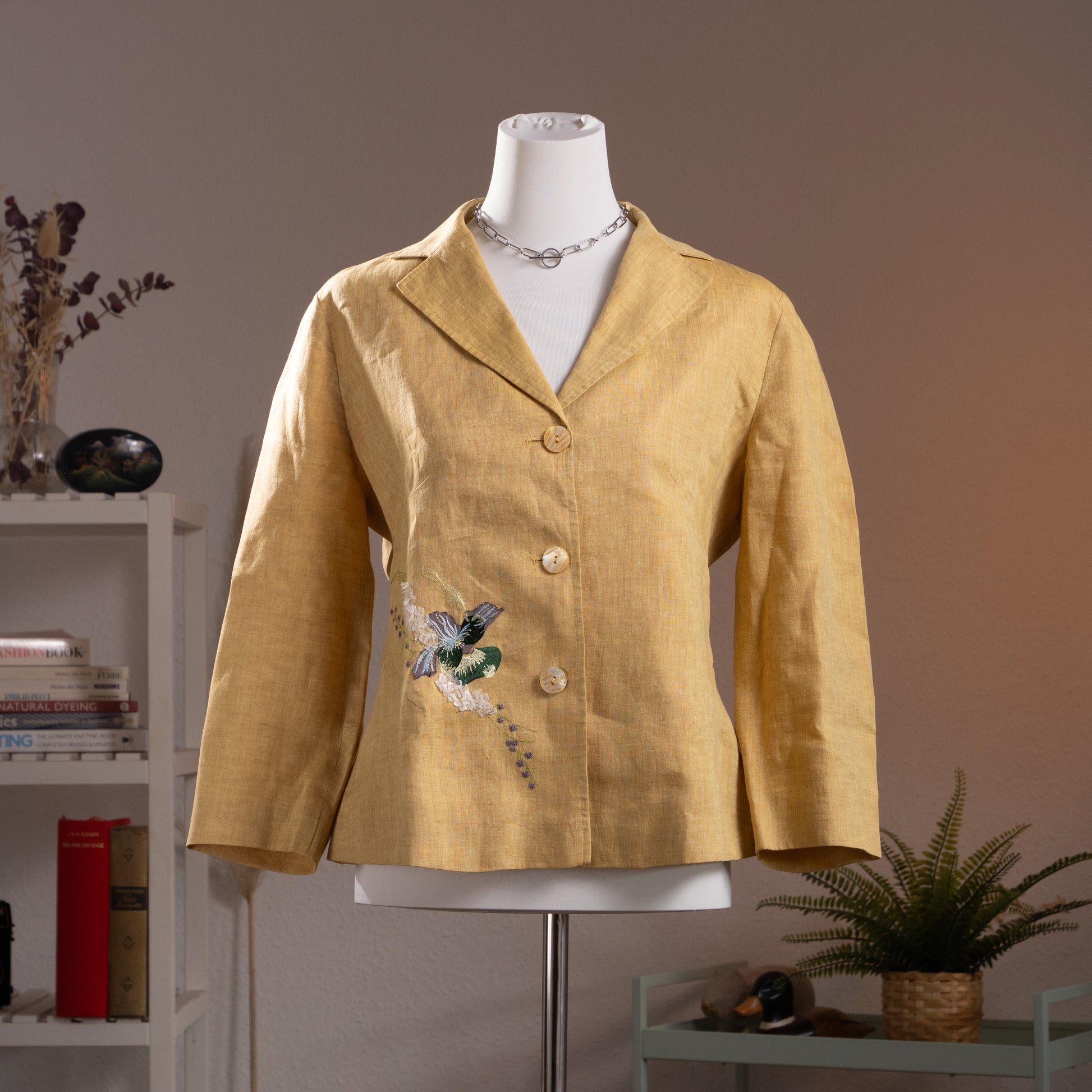 NOS Archival Kenzo Jungle Paris Deadstock 90s Yellow Linen Blazer – warm golden yellow linen, notch lapel, single-breasted with three mother-of-pearl buttons, 3D hummingbird and floral appliqué at lower front, long sleeves, fitted silhouette, product shot on dress form