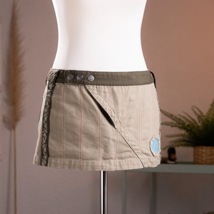 Front view of an archival Diesel asymmetrical wrap mini skirt in khaki pinstripe canvas and olive twill waistband, showcasing early 2000s Y2K utility and cyber grunge aesthetic.
