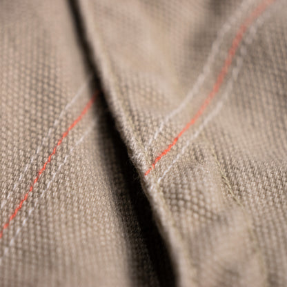 Detailed macro shot of the archival Diesel mini skirt's side twill tape, showcasing intricate contrasting off-white soutache chain-stitch embroidery in organic botanical vine motifs.
