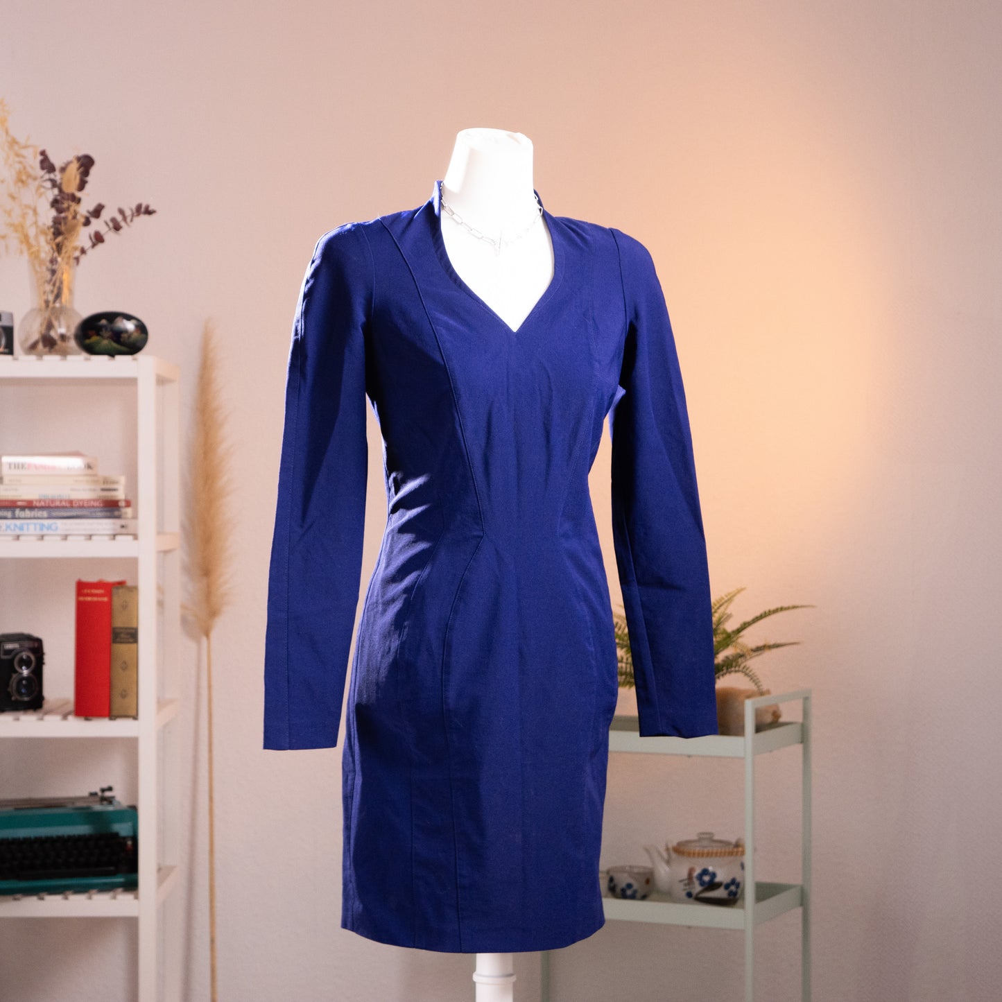 Archival Thierry Mugler Activ royal blue hourglass dress from the 1990s, showcasing structural panels, a deep V-neckline with a standing mandarin collar, and sharp padded shoulders. Front view on mannequin, pristine New Old Stock condition.
