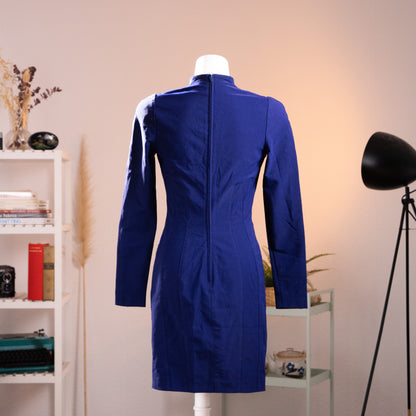 Full back view of the 1990 Thierry Mugler Activ dress on a mannequin, highlighting the architectural panel tailoring with four continuous vertical Princess seams and structural padded shoulders in highly saturated royal blue.
