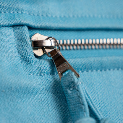 Macro shot of the authentic Swiss-made silver metal riri zipper on the archival early 1980s Courrèges Paris jacket, demonstrating pristine hallmark stamping and factory-knotted textile pull cord.
