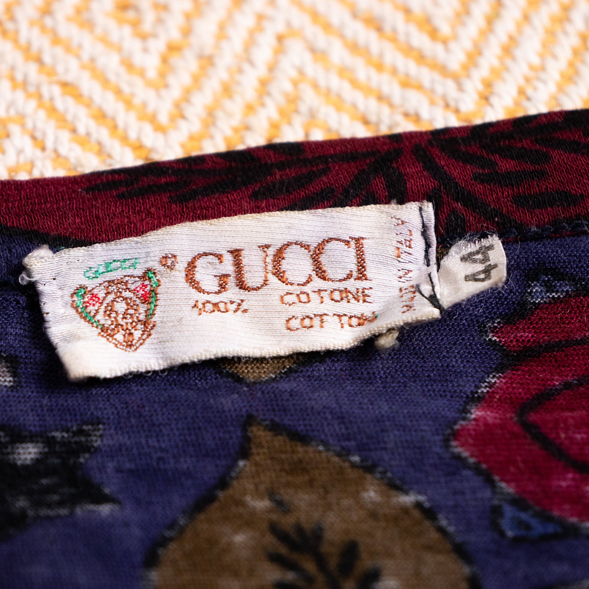 Woven vintage Gucci Crest neck label with size tag 44 from the Aldo Gucci era showcasing single-side vertical stitching.