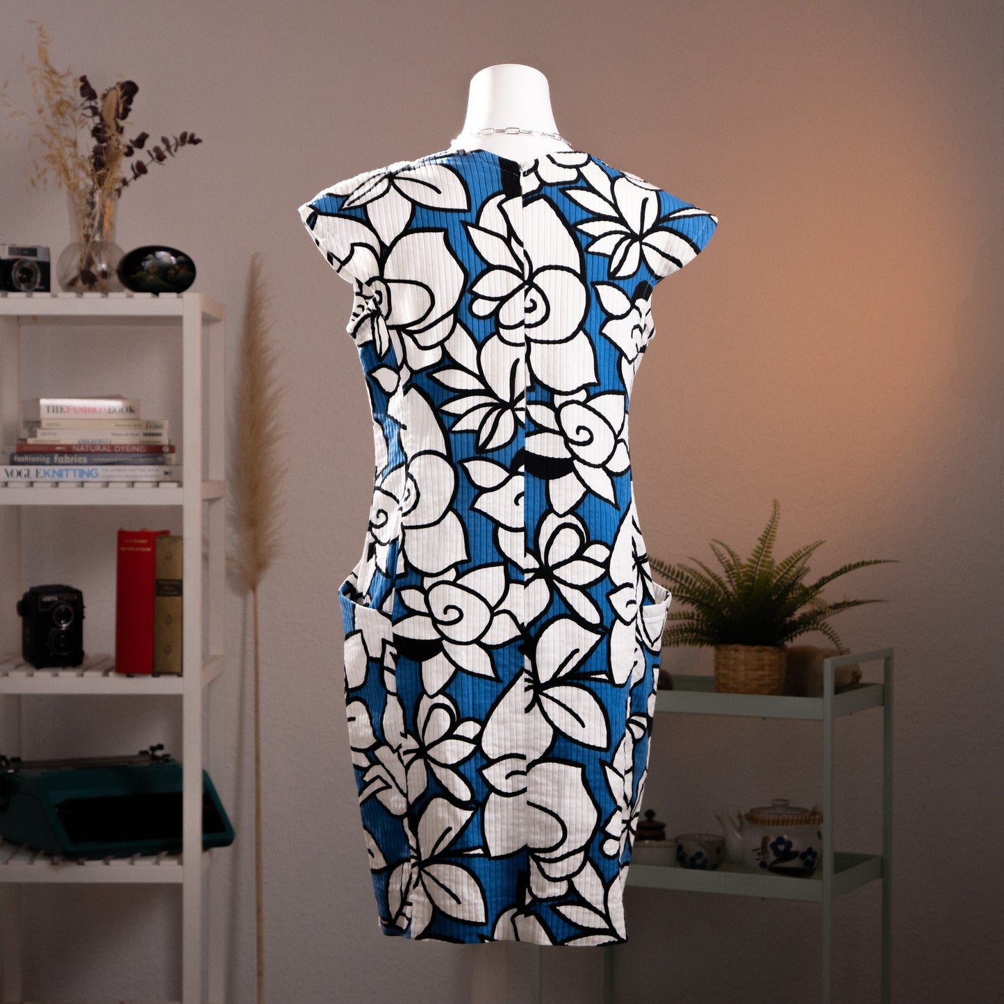 Rear view of vintage late 1980s Courrèges pleated floral shift dress showcasing the concealed back zipper and continuous pattern alignment.