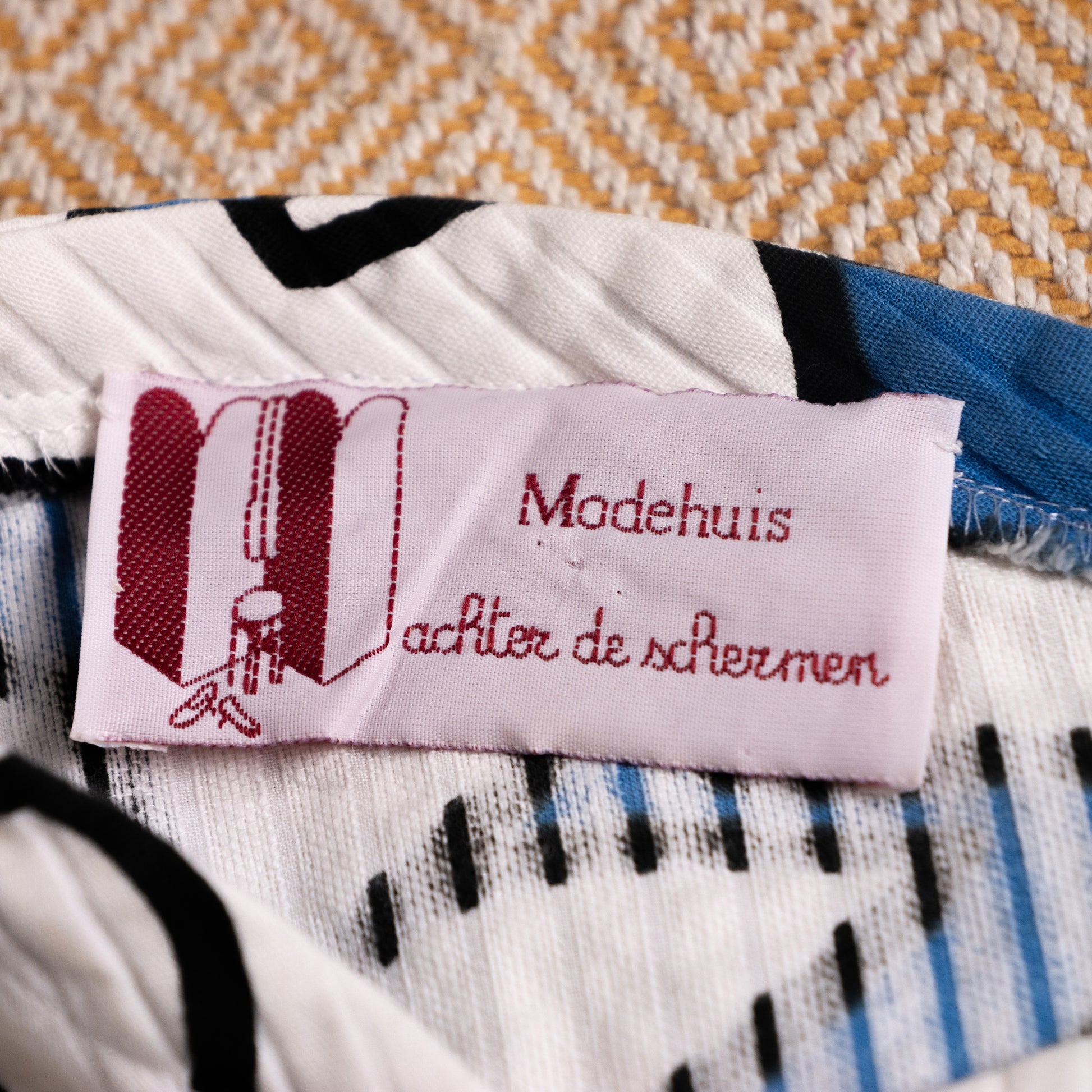 Close-up of the vintage Dutch retail boutique label Modehuis achter de schermen attached to the interior neckline of the Courrèges dress.