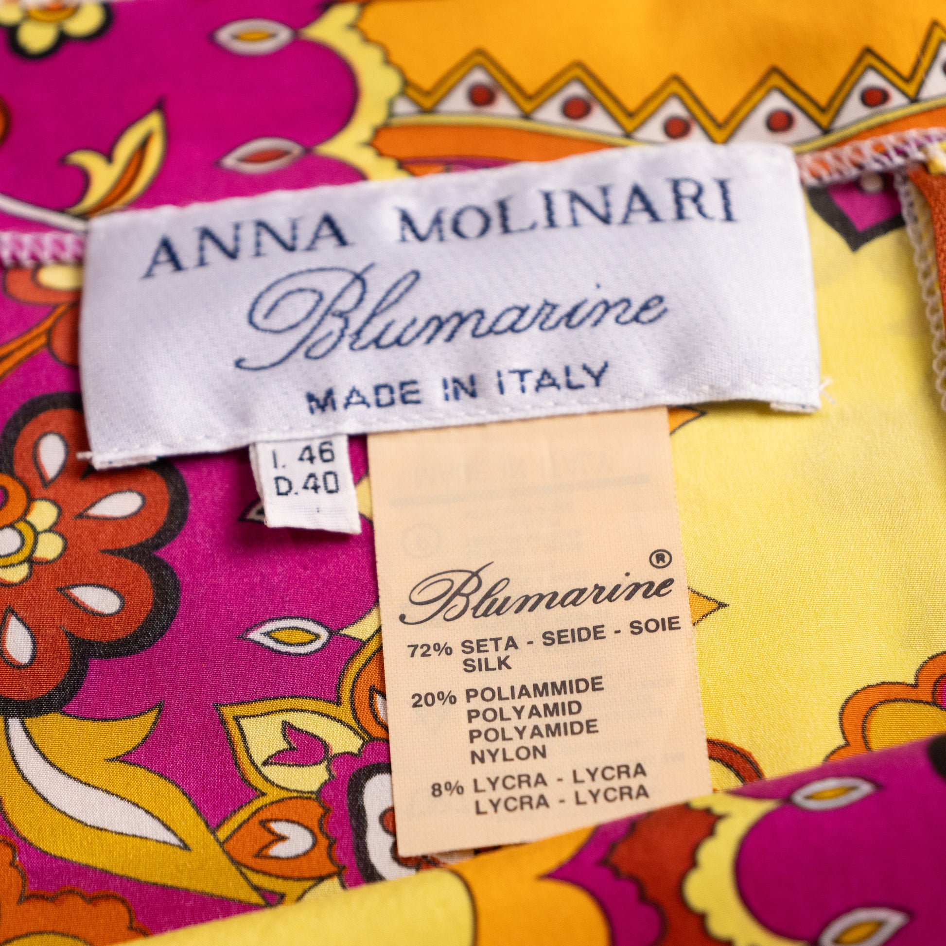 Macro shot of the pristine vintage Anna Molinari Blumarine neck label with attached sizing and silk-lycra material composition tags