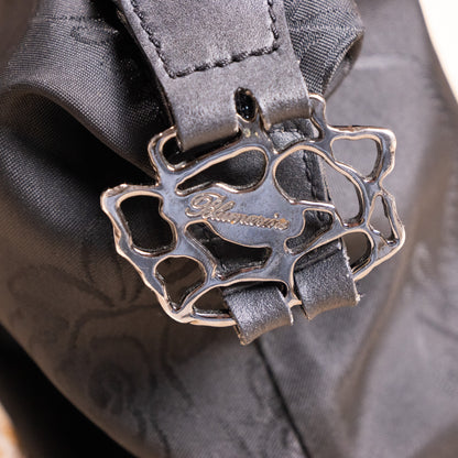 Close-up of sculptural silver-tone rose-vine metal buckle with engraved Blumarine logo on the archival deadstock baguette bag.