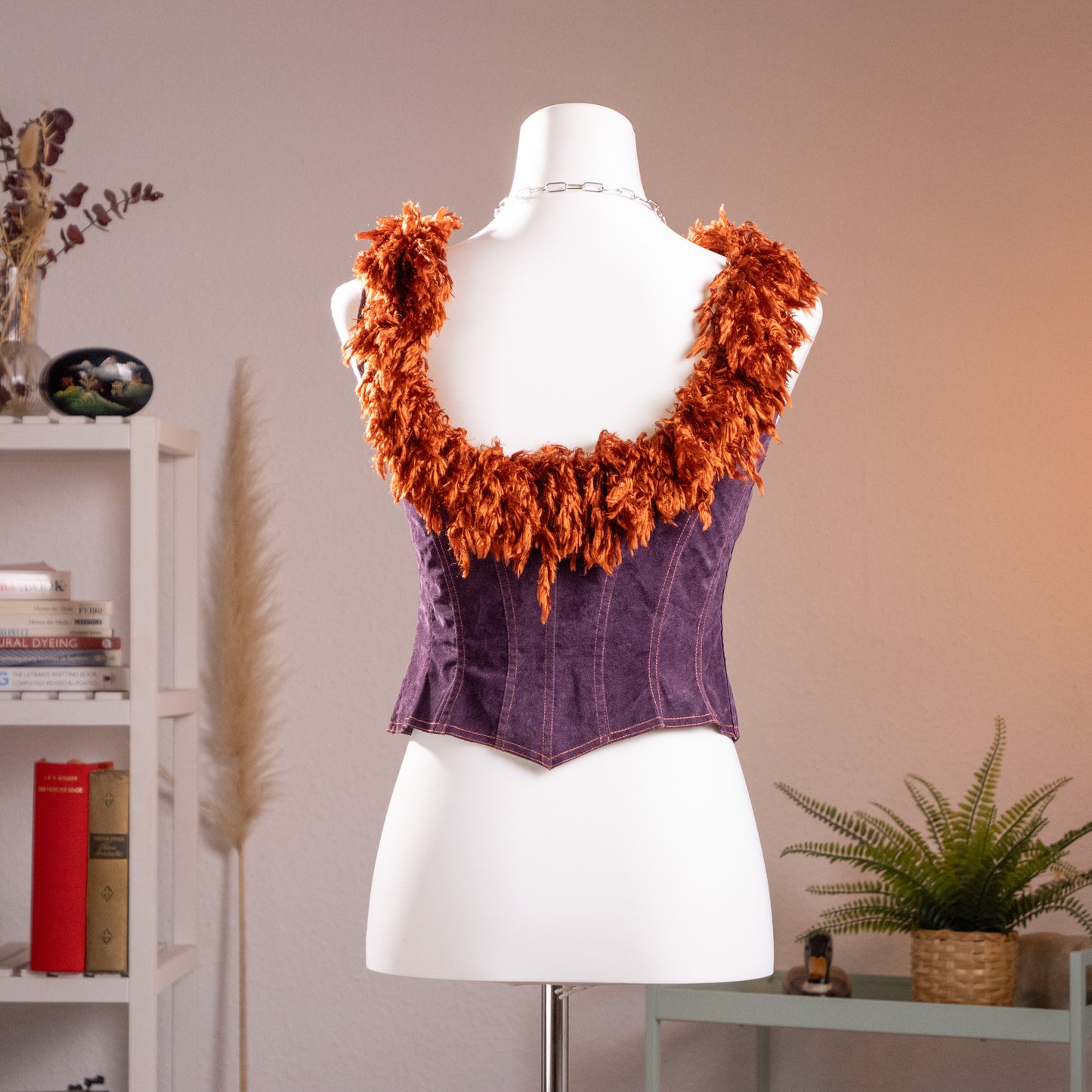 Rear view of the archival Lolita Lempicka deep purple faux suede corset top on a mannequin, showcasing the low-scoop back and copper shag fringe.