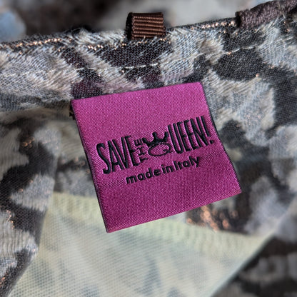 Purple tag with 'SAVE A QUEEN! made in Italy' text on a camouflage .background Save The Queen Archival Y2K Patchwork Midi Dress – ivory and grey mixed-media construction combining snake-print silk, diamond-weave linen, crochet lace and satin panels, asymmetric centre-front placket with large dark resin button closures, scoop neckline, sleeveless, ivory satin hem band with floral embroidery and fringe trim, art-to-wear, Marco Fantini Firenze, product shot on dress form